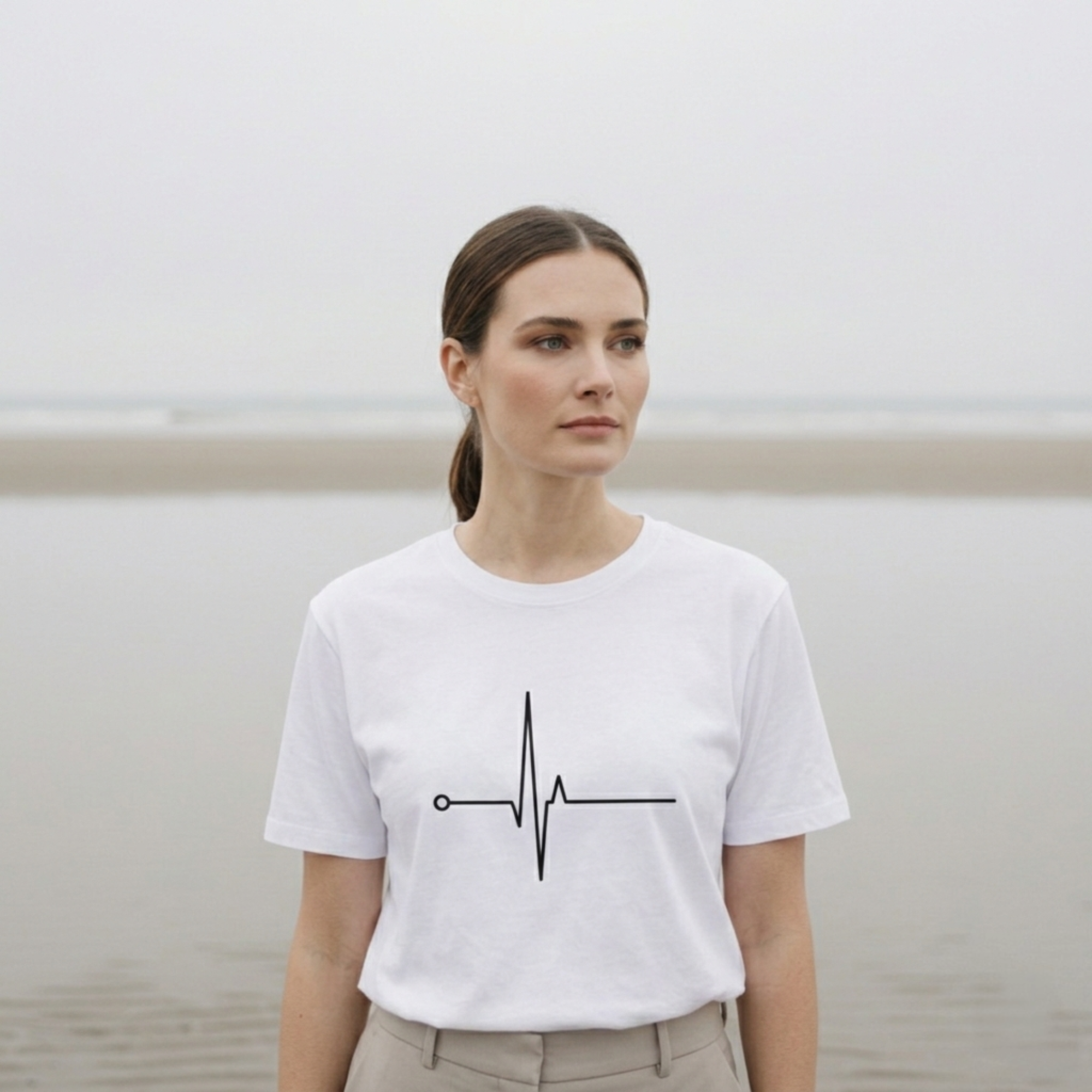 Woman wearing a white t-shirt with a black heartbeat design on a plain background.