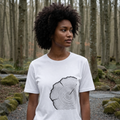 Woman wearing a white t-shirt with a tree ring design in a forest setting.
